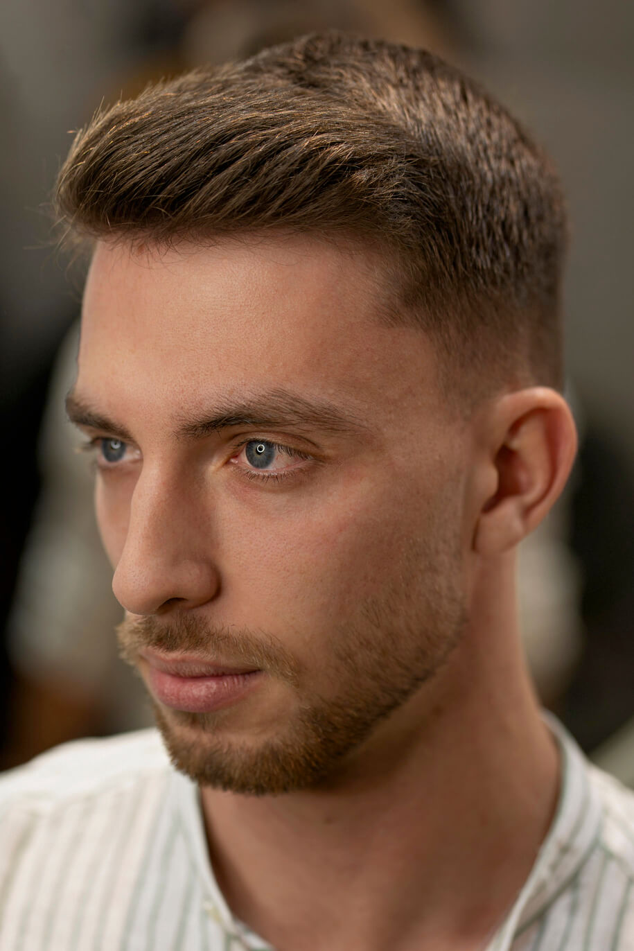 Perfil lateral de un hombre con corte fade degradado y textura natural en la parte superior, peinado con arcilla de acabado mate Waverk.