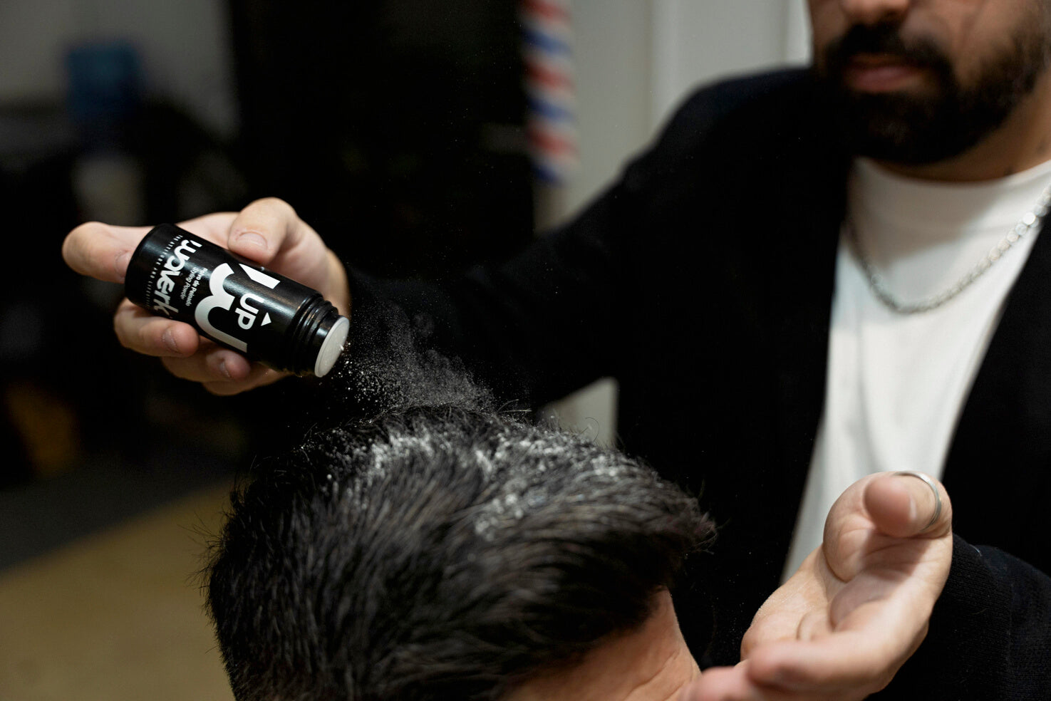 Primer plano de un hombre con cabello rizado y corte degradado lateral, texturizado con crema moldeadora Waverk para un look fresco y con volumen.